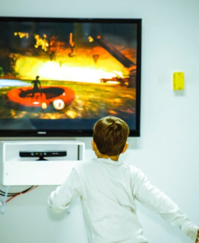 boy standing in front of flat screen tv
